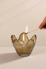 Hand lighting a candle in a decorative flower glass candle